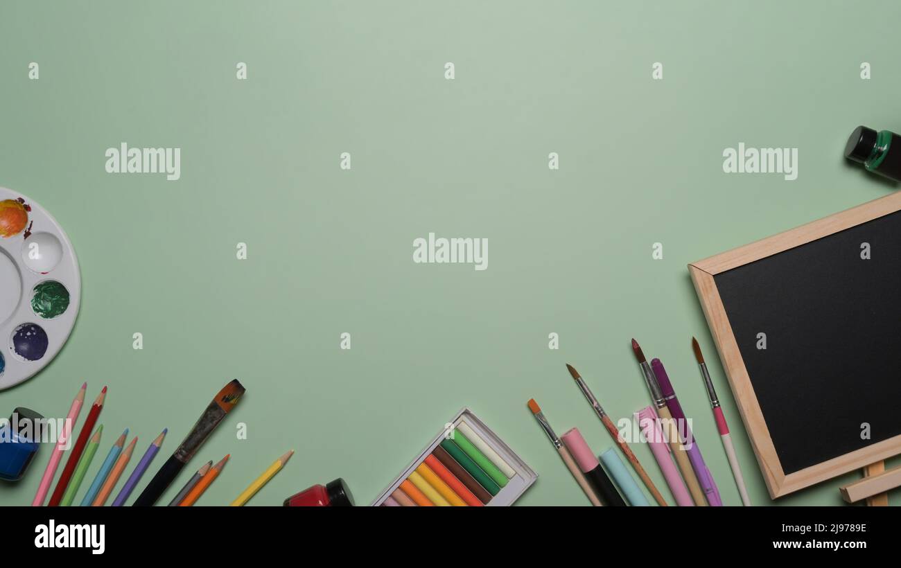 Chalkboard and school stationery on green background. Back to school ...