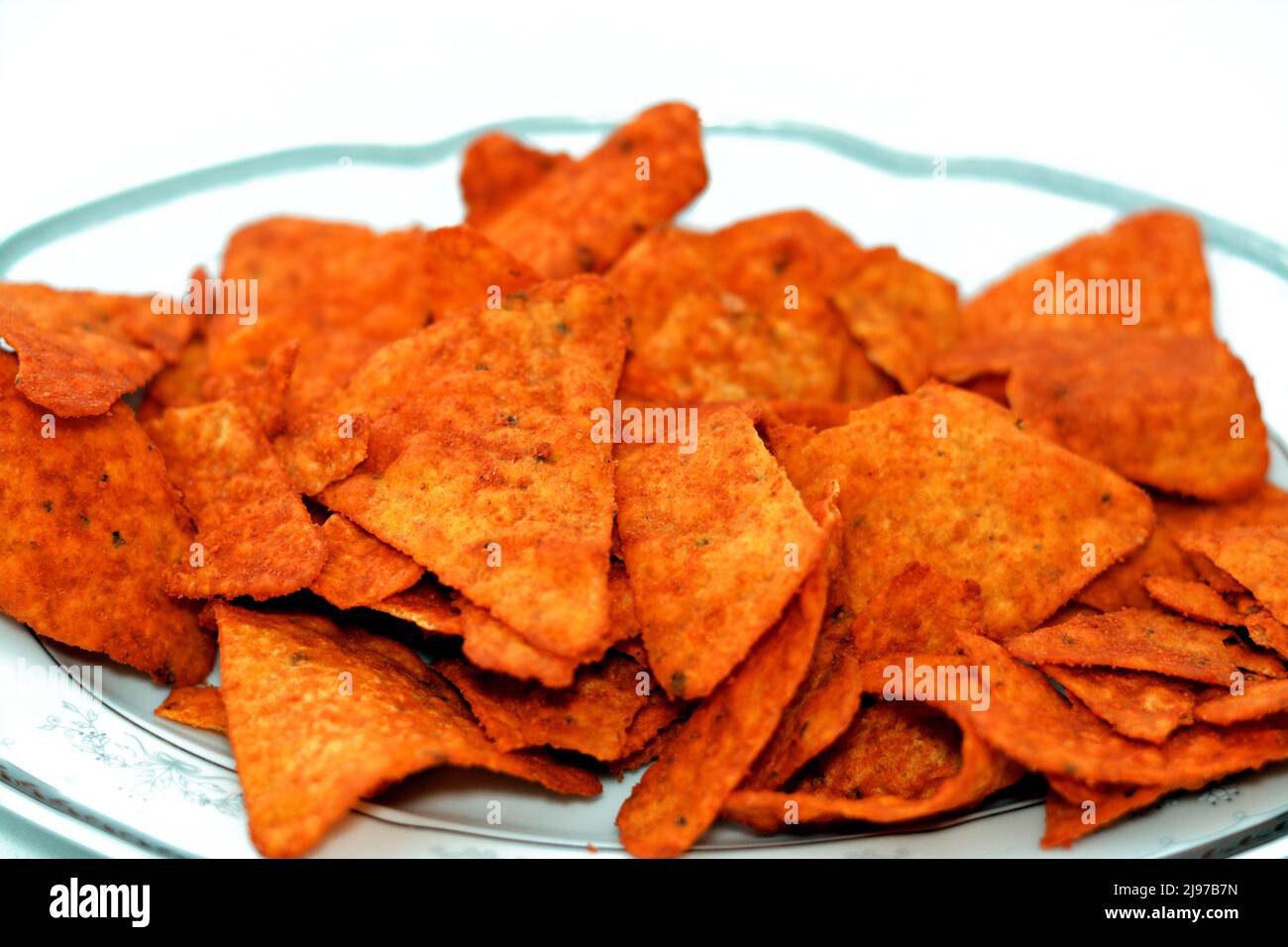 A pile of flavored tortilla chips made of corn tortillas cut into ...