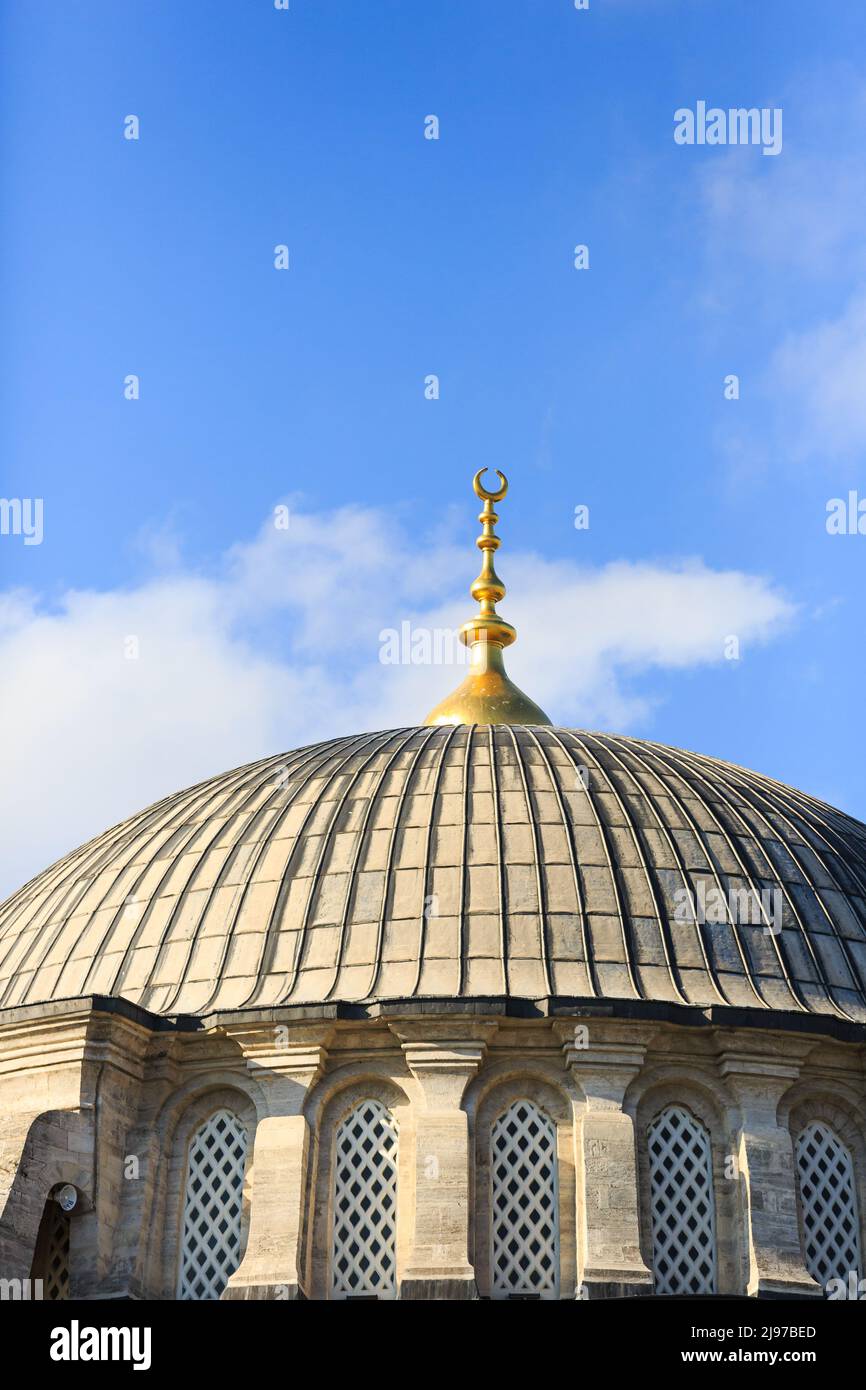 Dome of a mosque with golden alem finial on a sunny day with blue skies. Stock Photo