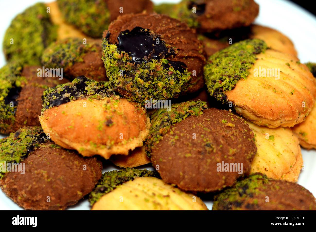 Traditional Arabic cookies for celebration of Islamic holidays of El-Fitr feast, petit four bakery (mignardises) stuffed with jam and nuts and covered Stock Photo