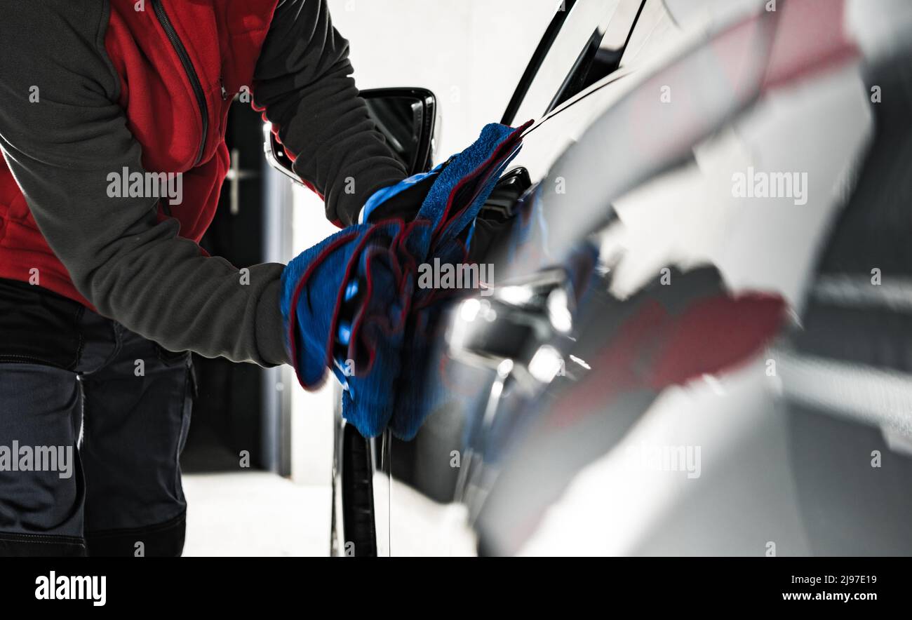 Car Wash Worker Detailing Modern Vehicle Body Using Soft Cloth