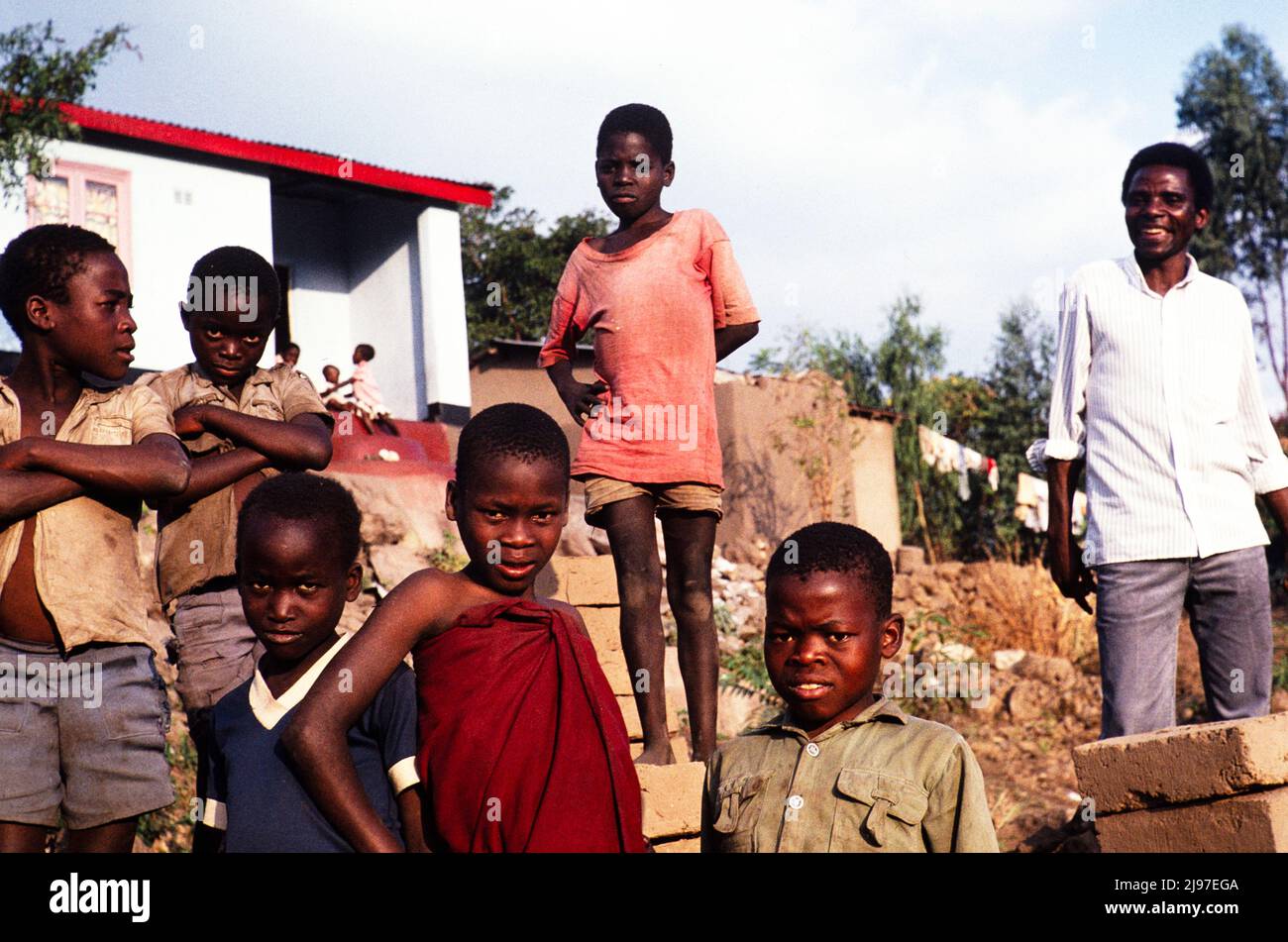 Man standing with group of boys who have been carrying bricks for him