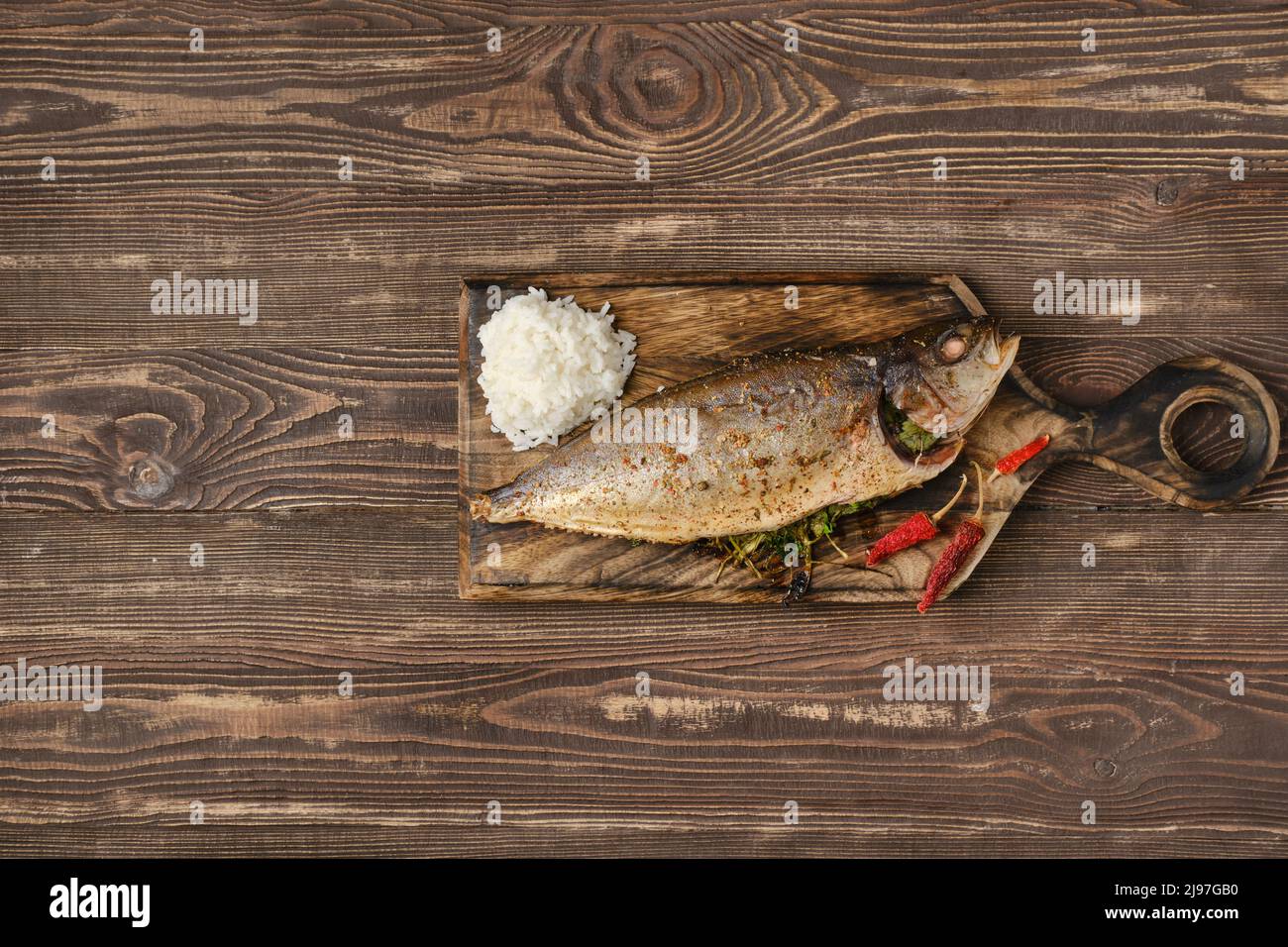 Baked sea yellow tailed mackerel on wooden cutting board, top view Stock Photo