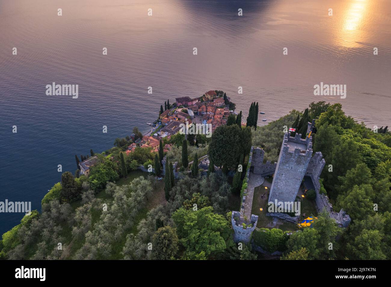 Aerial view of Vezio Castle and Varenna village in background during summer sunset. Drone shot in Como lake. Varenna, Italy Stock Photo