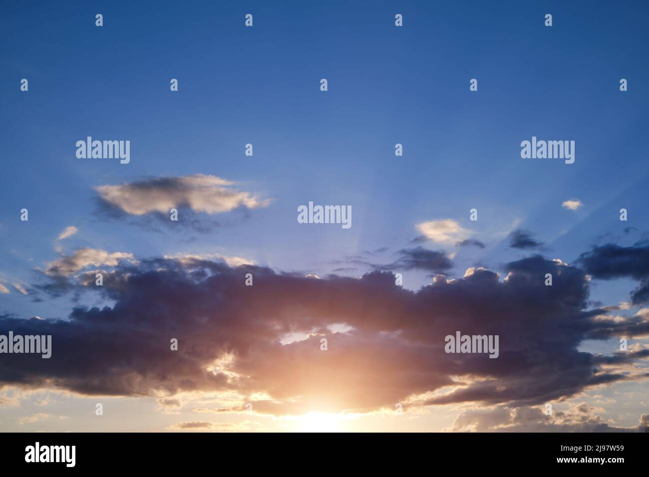 Clouds at sunset with rays sun breaking through them Stock Photo