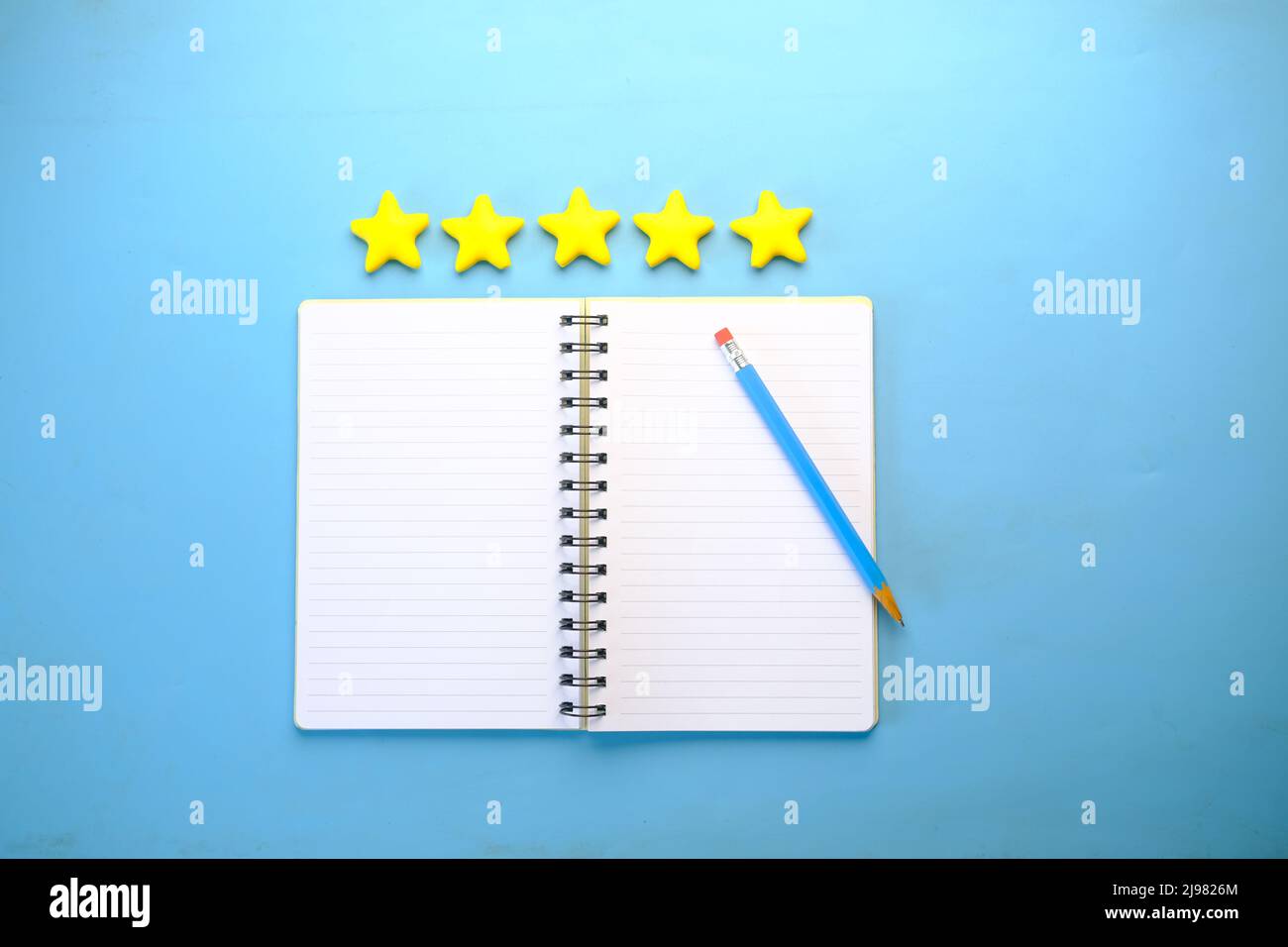 Customer review concept. Rating golden stars and notepad on blue ...