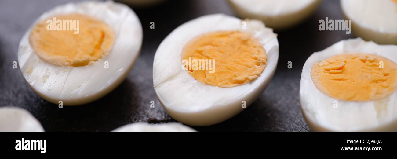 Boiled chicken eggs cut in half on dark background Stock Photo