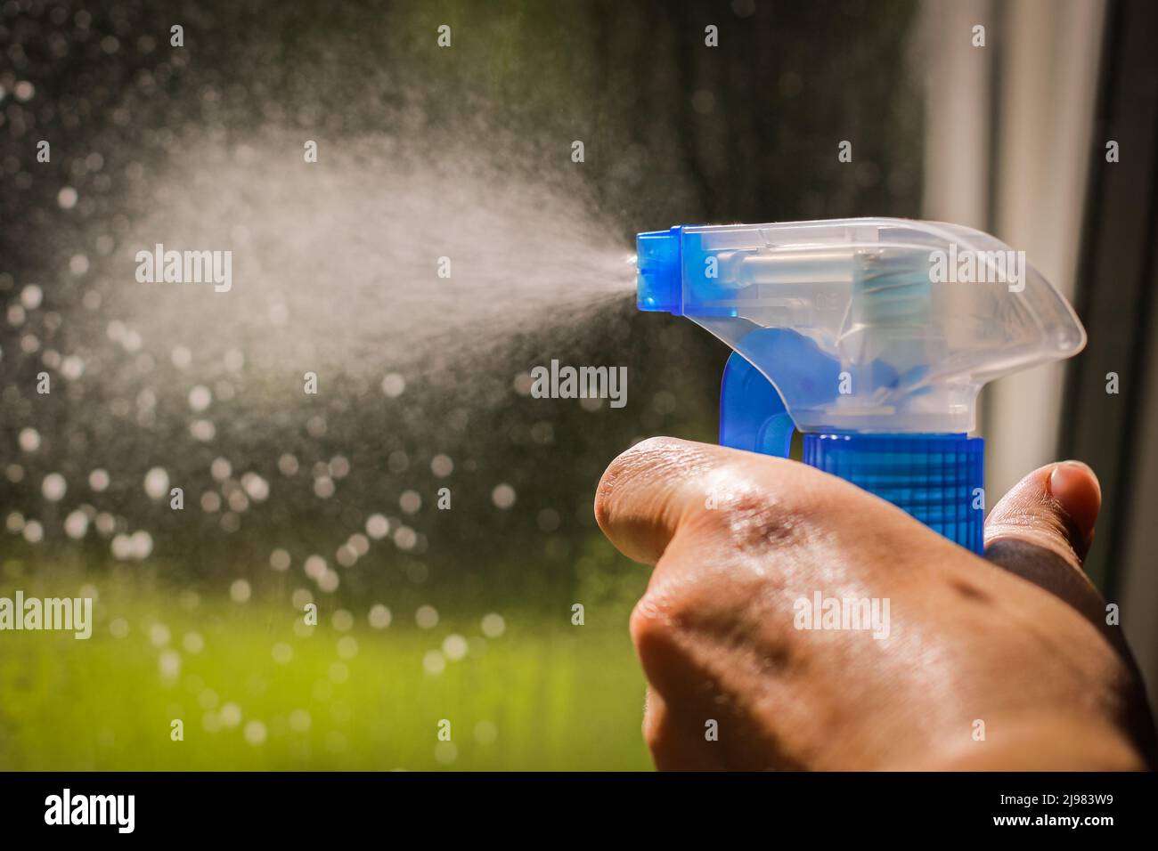 Cleaning windows with detergent spray. Washing the glass Stock Photo