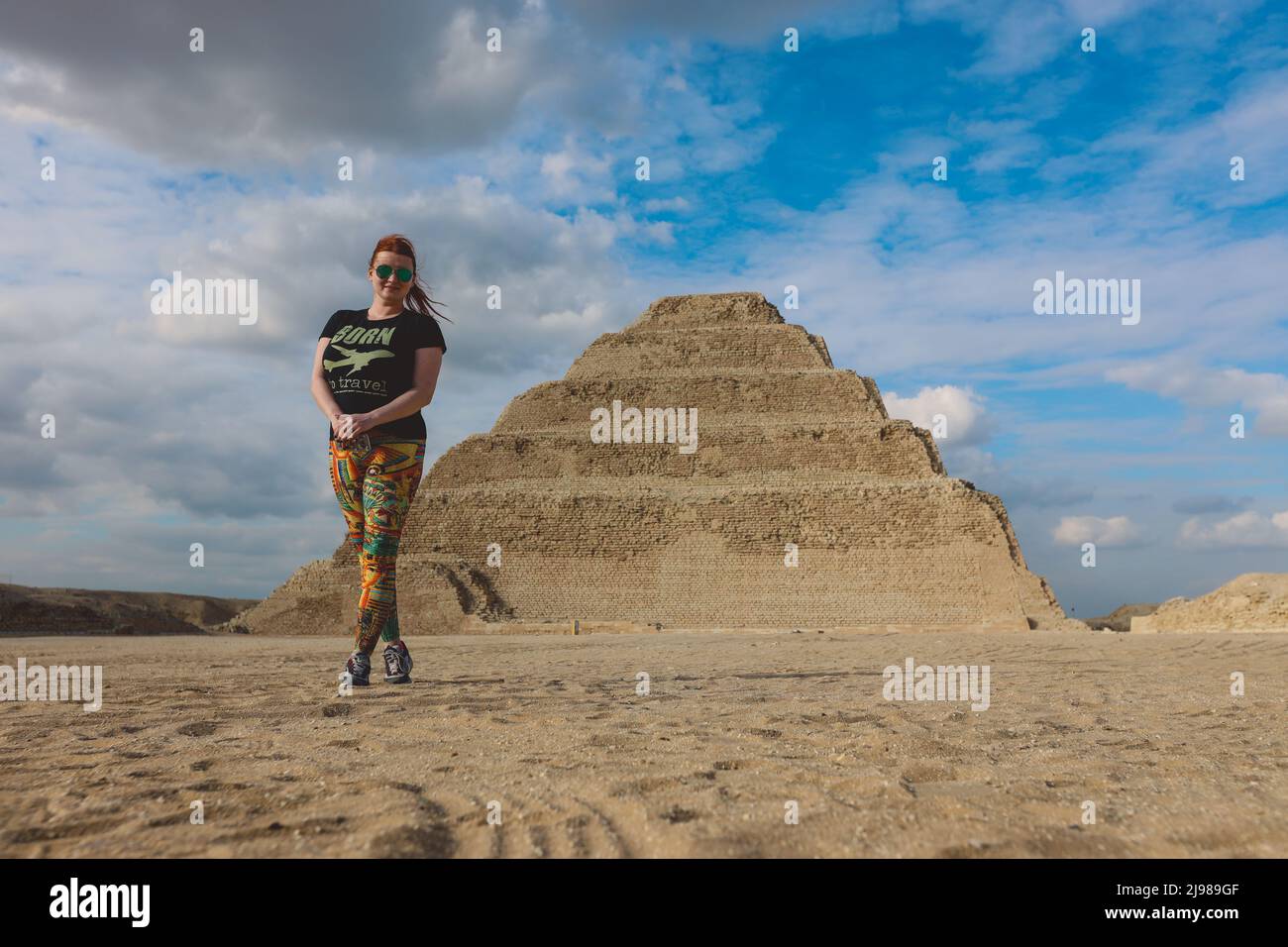 One Tourist Posing with the Step Pyramid of Djoser on the background in the Saqqara necropolis archaeological site, northwest of the city of Memphis Stock Photo