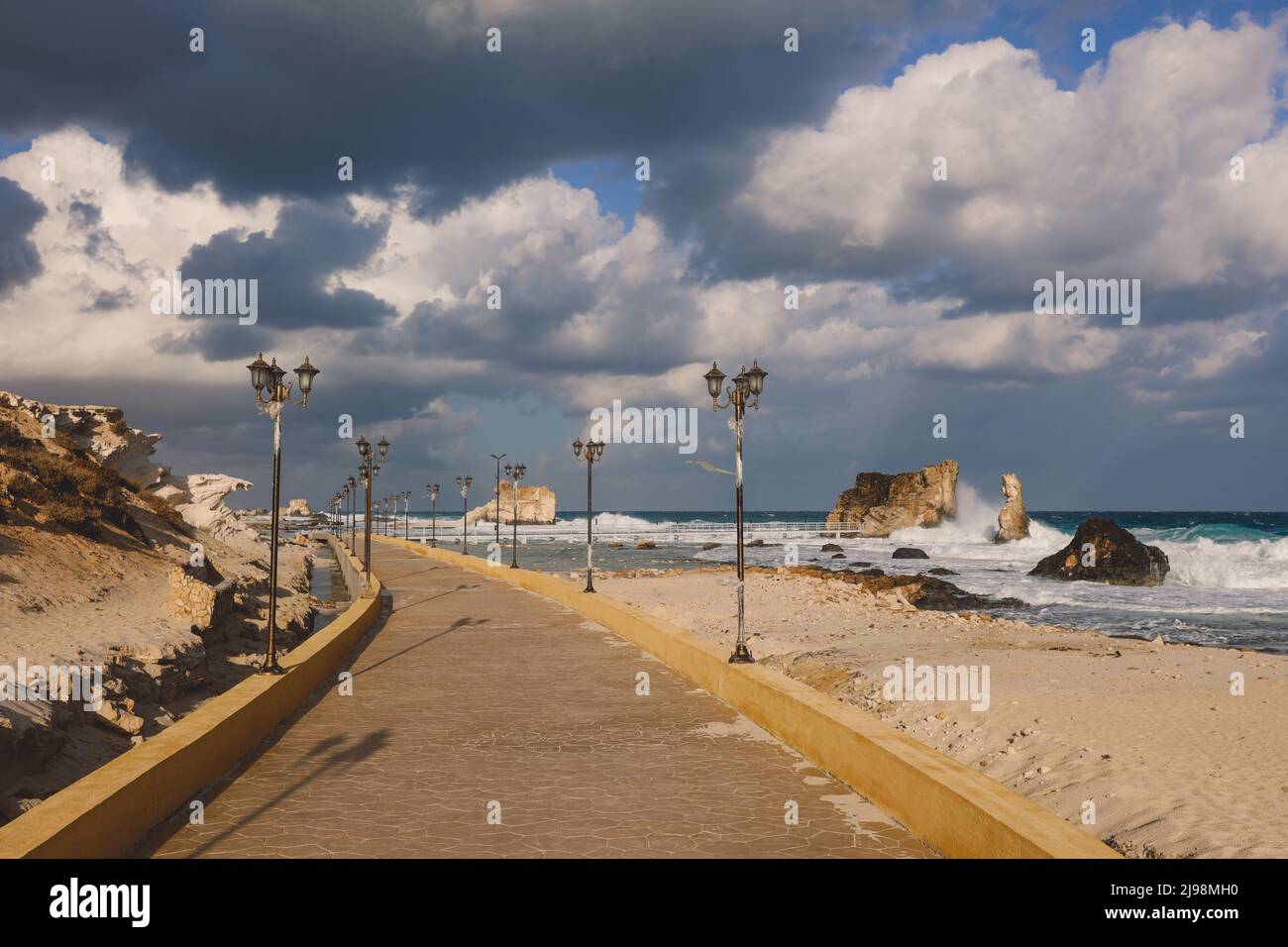 Windy and Rocky Coastline of the Mediterranean Sea in the Marsa Matruh city under Blue Cloudy sky with no People around, Egypt Stock Photo