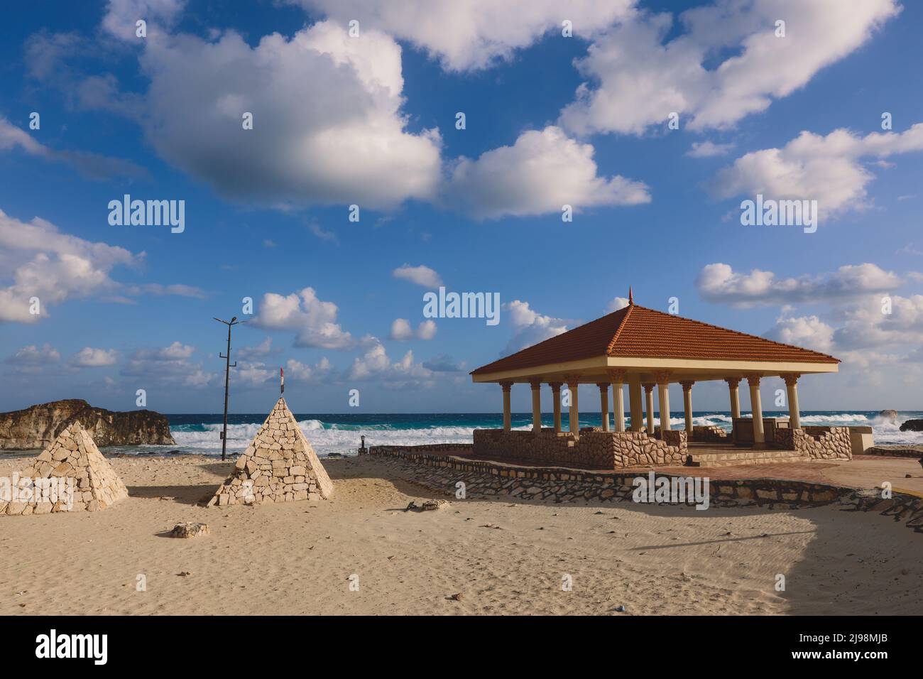 Windy and Rocky Coastline of the Mediterranean Sea in the Marsa Matruh city under Blue Cloudy sky with no People around, Egypt Stock Photo