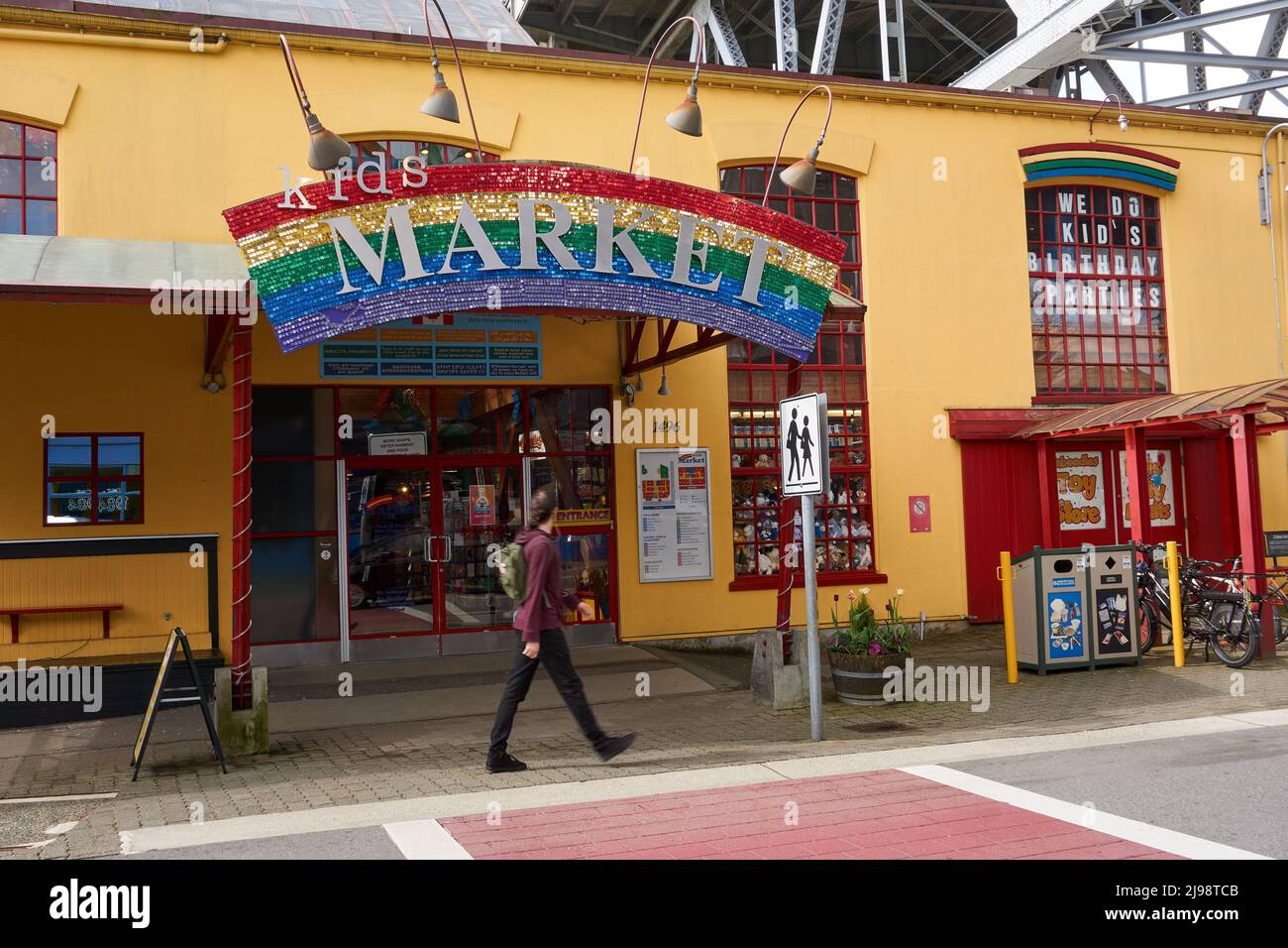 Person walking past the Kids Market children's shopping mall on Granville Island, Vancouver, BC, Canada Stock Photo