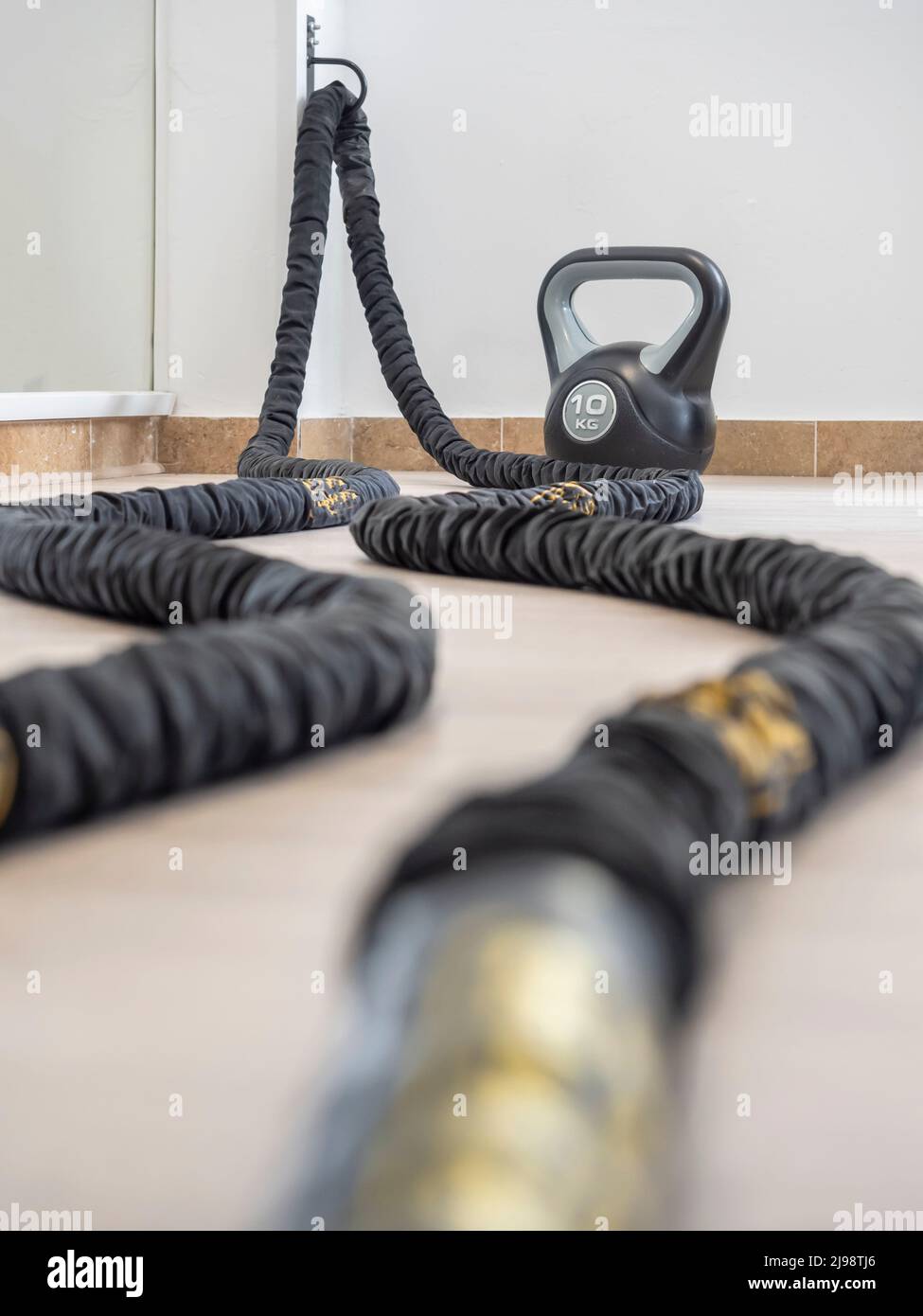 Fitness Kettlebell and battle rope on the gym floor Stock Photo Alamy