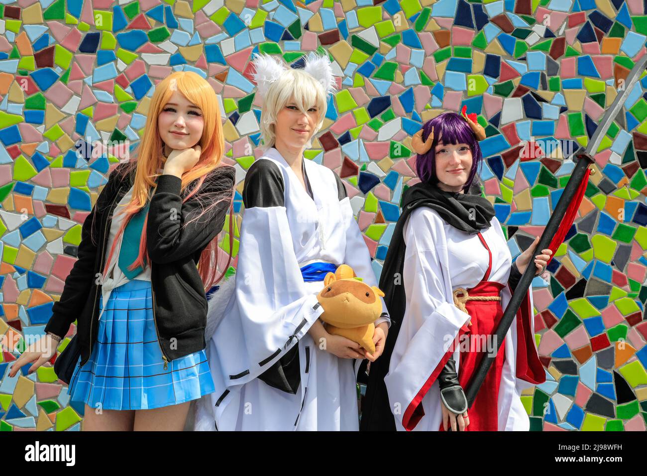 Düsseldorf, NRW, Germany. 21st May, 2022. Cosplayers happily pose by the mosaic tiling wall along the riverbank. Tens of thousands of visitors and cosplayers enjoy the warm sunshine along the river Rhine embankment in their outfits inspired by Japanese anime, video and games. Stage performances, cosplay, stalls and demonstrations of Japanese culture, sports and traditions are featured at Düsseldorf's annual Japan Day, celebrating Japan and the Japanese community in the city. Düsseldorf is home to the largest Japanese community in Germany. Credit: Imageplotter/Alamy Live News Stock Photo