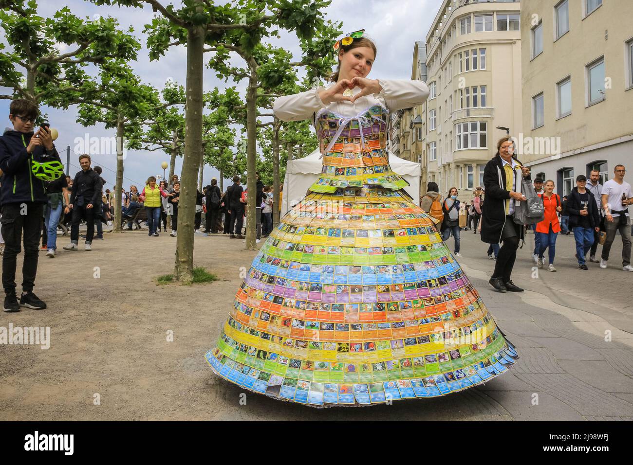 Düsseldorf, NRW, Germany. 21st May, 2022. A young woman has taken one year to complete her dress made from pokemon cards.Tens of thousands of visitors and cosplayers enjoy the warm sunshine along the river Rhine embankment in their outfits inspired by Japanese anime, video and games. Stage performances, cosplay, stalls and demonstrations of Japanese culture, sports and traditions are featured at Düsseldorf's annual Japan Day, celebrating Japan and the Japanese community in the city. Düsseldorf is home to the largest Japanese community in Germany. Credit: Imageplotter/Alamy Live News Stock Photo