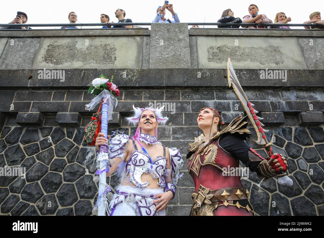 Düsseldorf, NRW, Germany. 21st May, 2022. People watch as cosplayers pose below. Tens of thousands of visitors and cosplayers enjoy the warm sunshine along the river Rhine embankment in their outfits inspired by Japanese anime, video and games. Stage performances, cosplay, stalls and demonstrations of Japanese culture, sports and traditions are featured at Düsseldorf's annual Japan Day, celebrating Japan and the Japanese community in the city. Düsseldorf is home to the largest Japanese community in Germany. Credit: Imageplotter/Alamy Live News Stock Photo