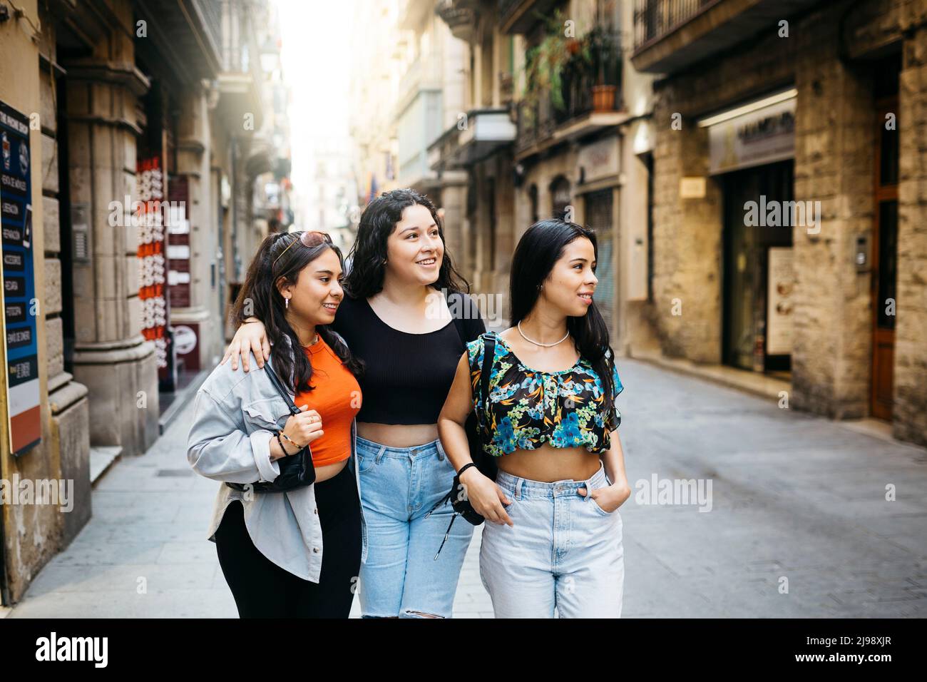 Three young women walking and hanging out on a comercial street of a big city Stock Photo
