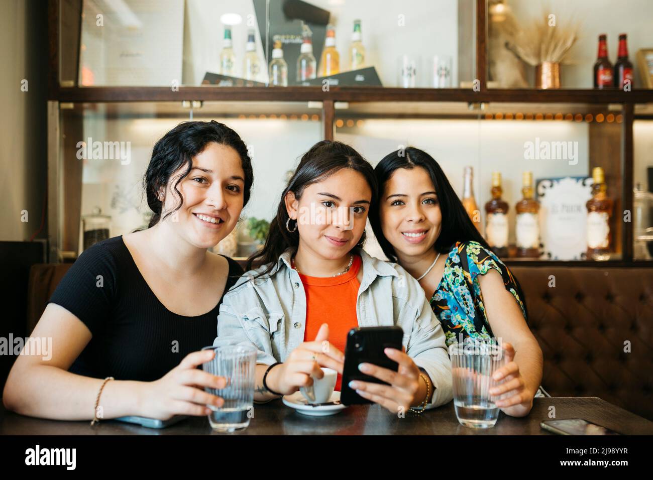Portrait of three young women looking at the camera in a restaurant Stock Photo