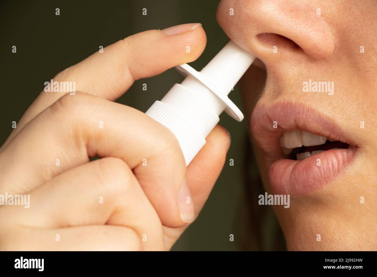 spray for a nose in a girl's nose, nose drops, gri n and colds, cannot breathe, nasal congestion, medicine Stock Photo