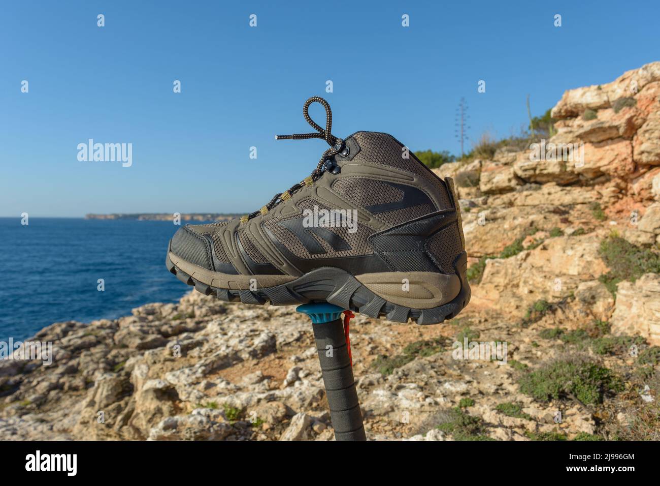 Olive green hiking boots on a natural background of sea and rocks Stock Photo Alamy