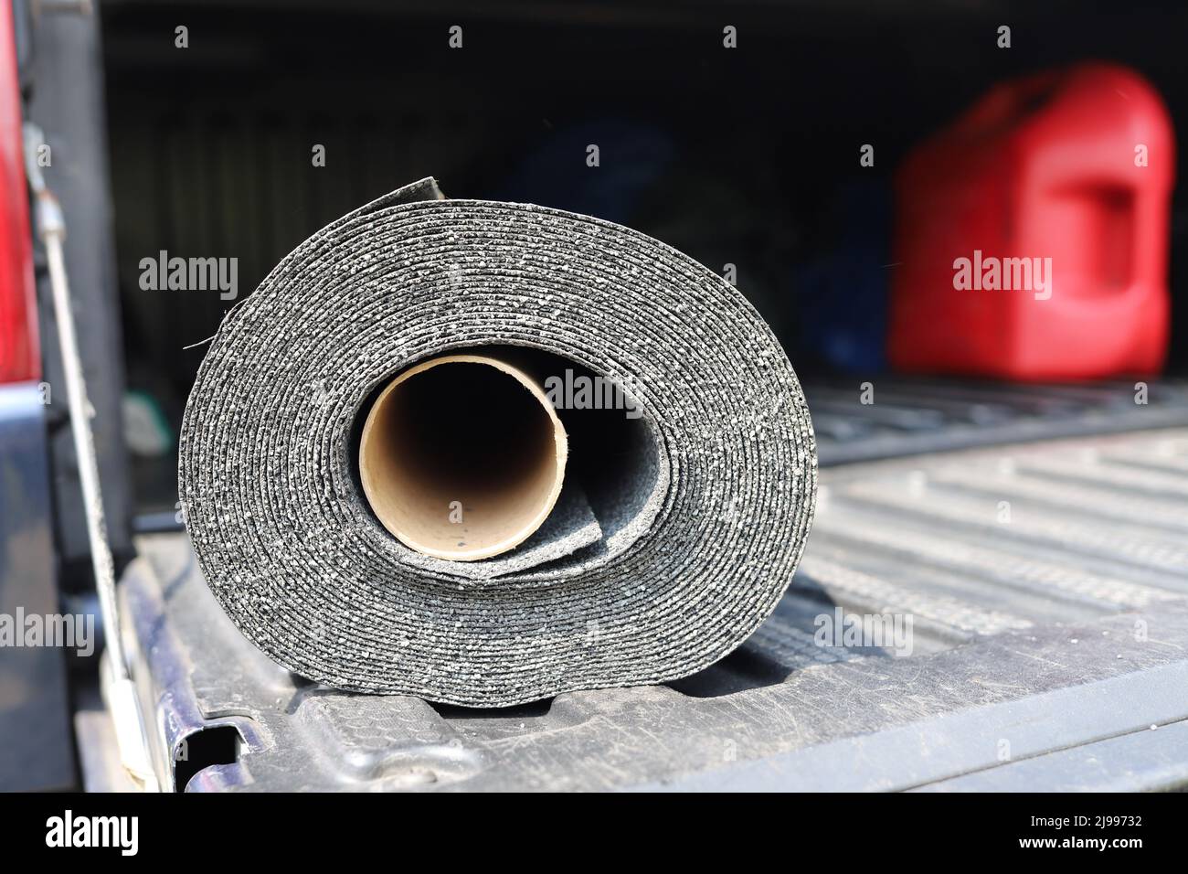Black Plastic Sheeting Roll in the back of a pickup truck Stock Photo
