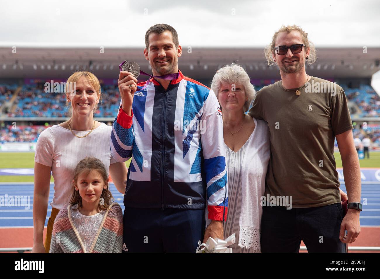 Birmingham, England. 21st May, 2022. Robbie Grabarz, with family, of Team GB receives a silver medal for the London 2012 High Jump following Ivan Ukhov being stripped of the gold medal at the Müller Diamond League athletics event at the Alexander Stadium in Birmingham, England. Credit: Sporting Pics / Alamy Live News Stock Photo