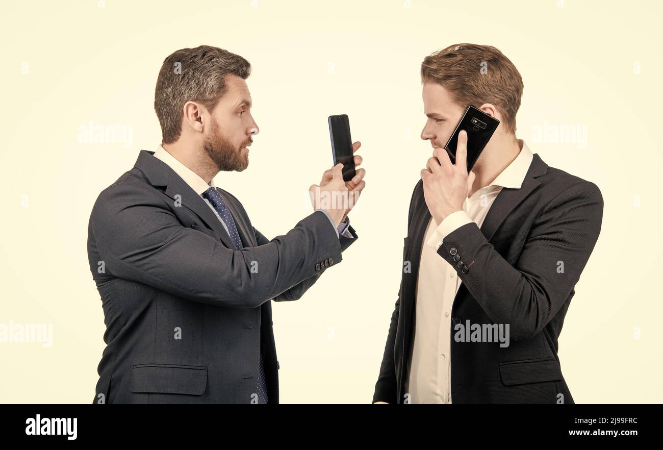 negotiation disagreement of talking man on smartphone and businessman showing phone, argue. Stock Photo