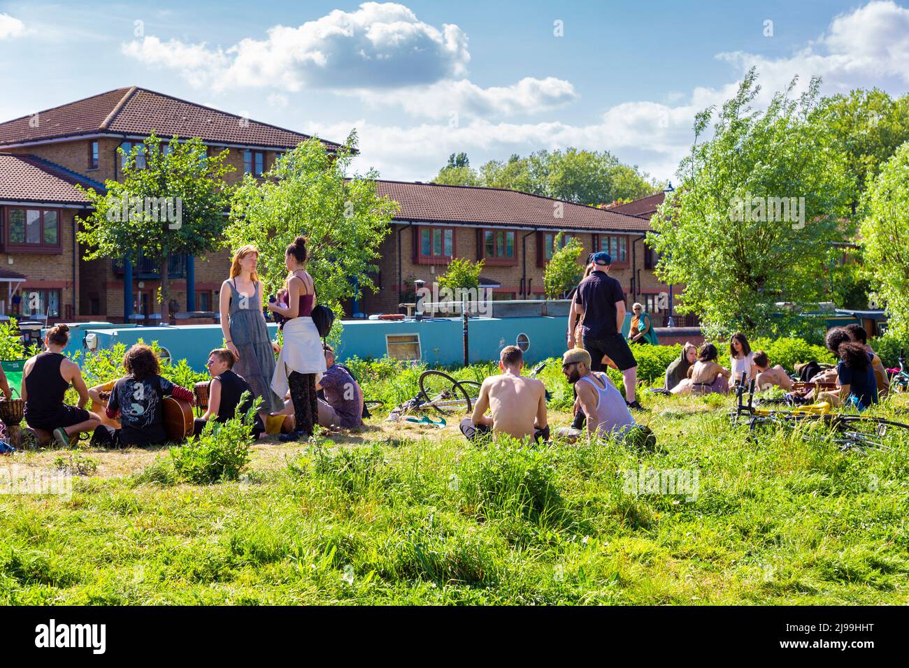People relaxing on a sunny day along the River Lee Navigation canal by Here East, Olympic Park, Stratford, London, UK Stock Photo