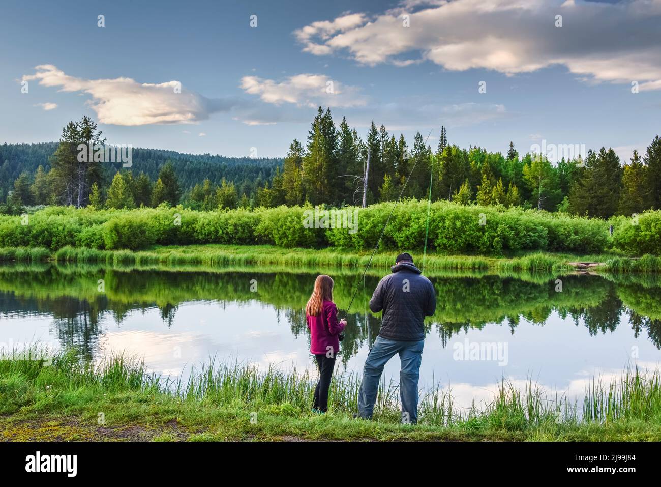 A father teaches his daughter how to fly fish on Stoddard Mill Pond, Island Park, Fremont County, Idaho, USA Stock Photo