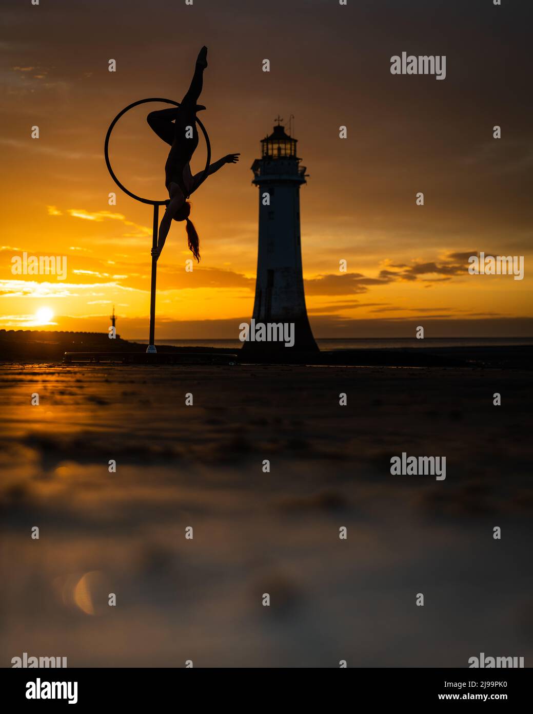 New Brighton, UK. 22nd May 2022 - Aerial artist, Megan Price practicing on New Brighton beach on the Wirral at sunset. Credit: Christopher Middleton/Alamy Live News Stock Photo