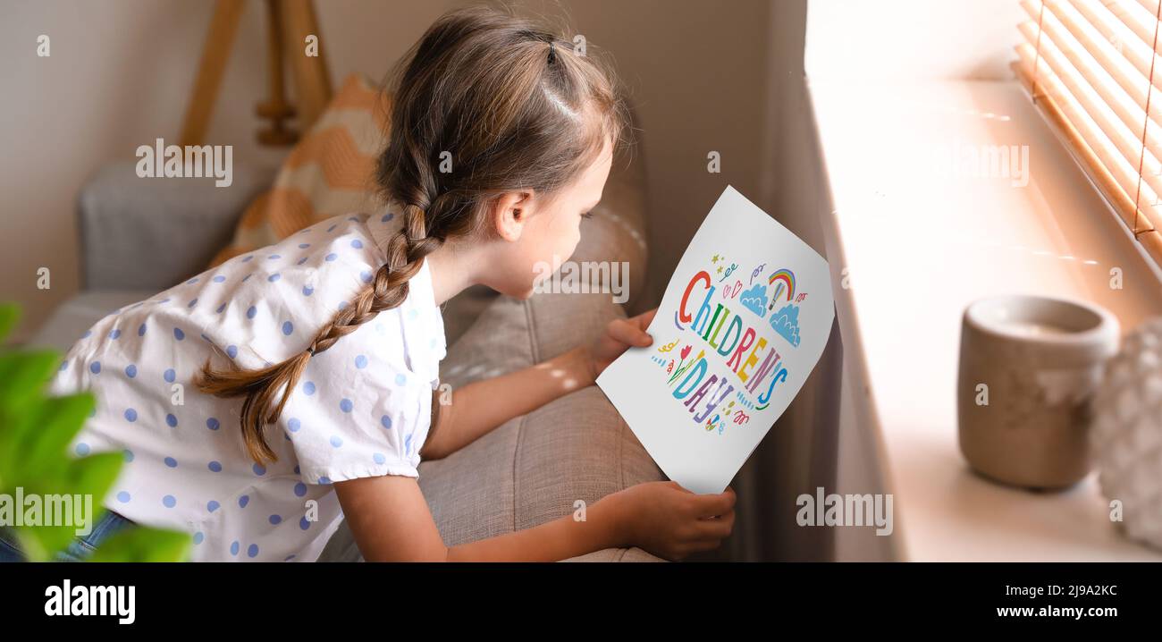 Funny little girl with card for Children's Day at home Stock Photo - Alamy