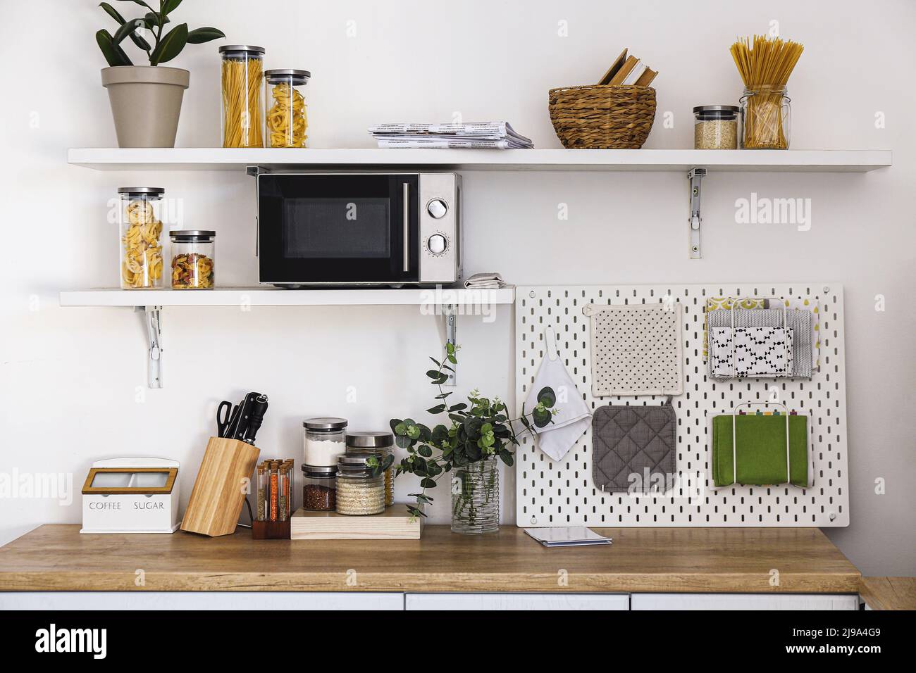 Modern kitchen with counter, shelves and pegboard near light wall Stock ...