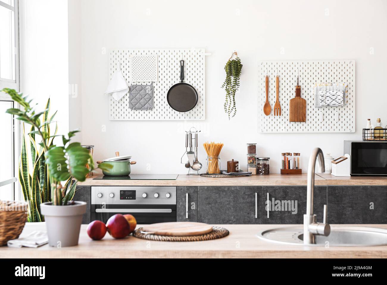 Interior of kitchen with modern counters and pegboards with utensils ...