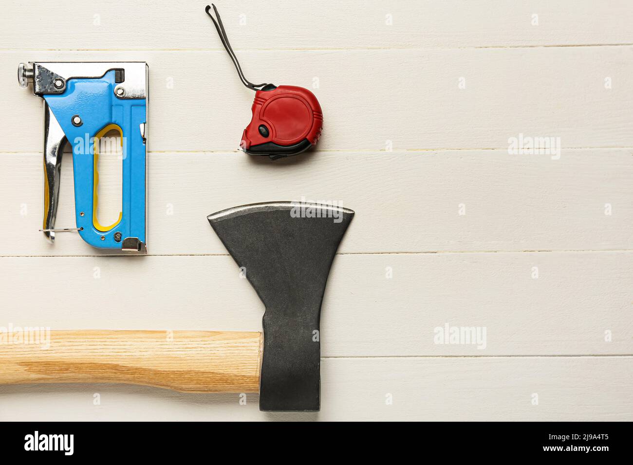 Building stapler, ruler and ax on white wooden background Stock Photo ...