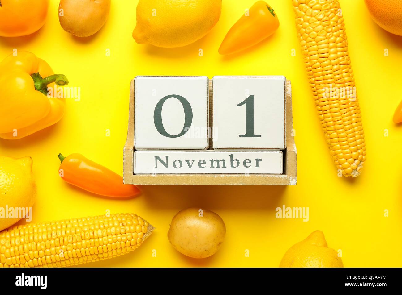 Wooden cube calendar with date NOVEMBER 1, fresh vegetables and fruits