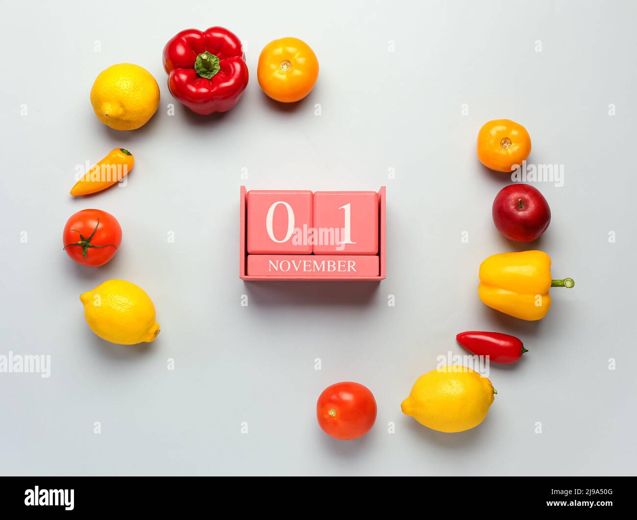 Fresh fruits, vegetables and cube calendar with date NOVEMBER 1 on grey