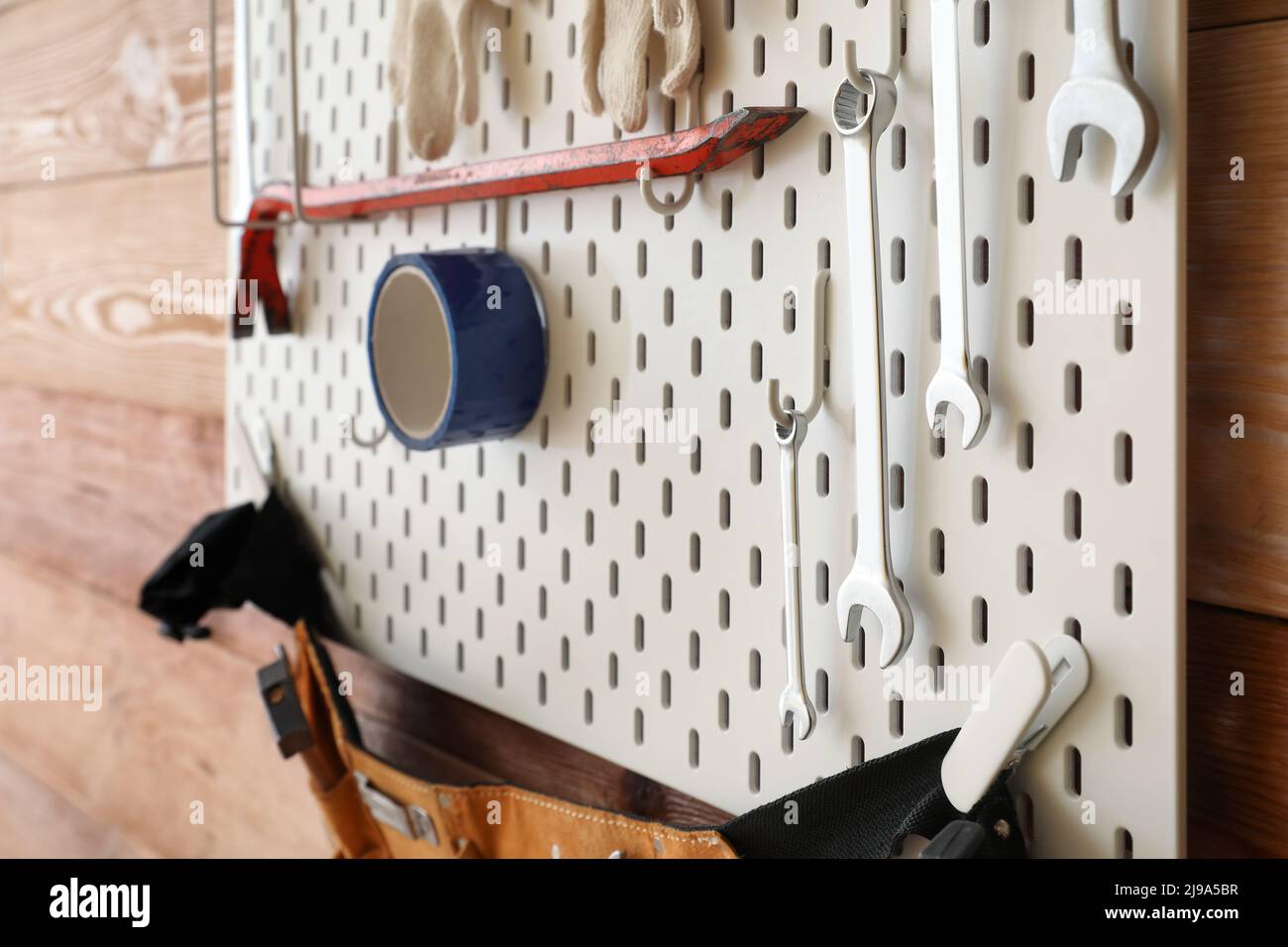 Pegboard with modern tools on wooden wall Stock Photo - Alamy