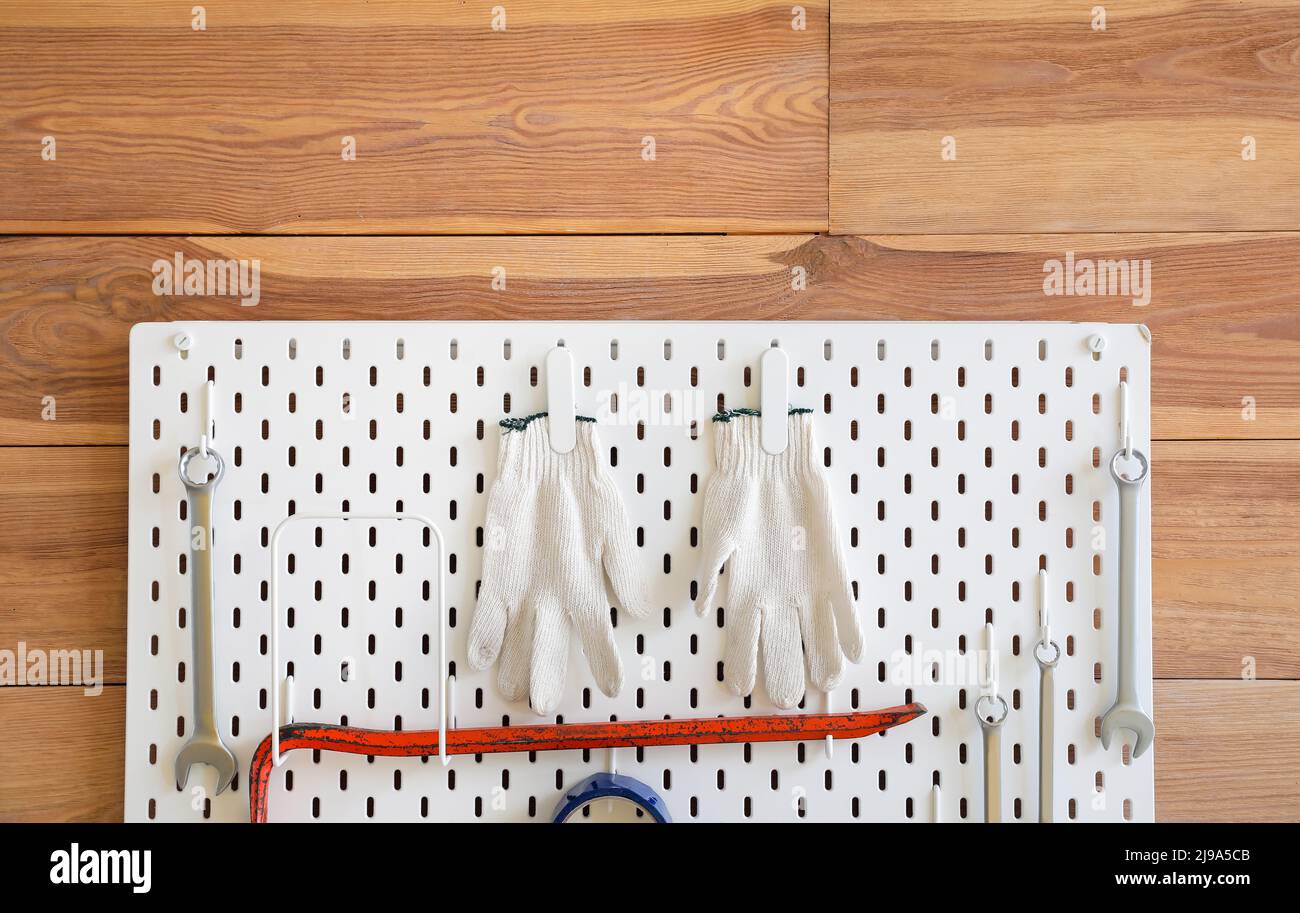 Pegboard with gloves, scrap and spanners on wooden wall Stock Photo Alamy