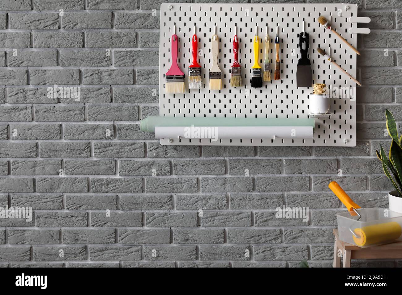 Pegboard with decorator's tools on grey brick wall Stock Photo Alamy