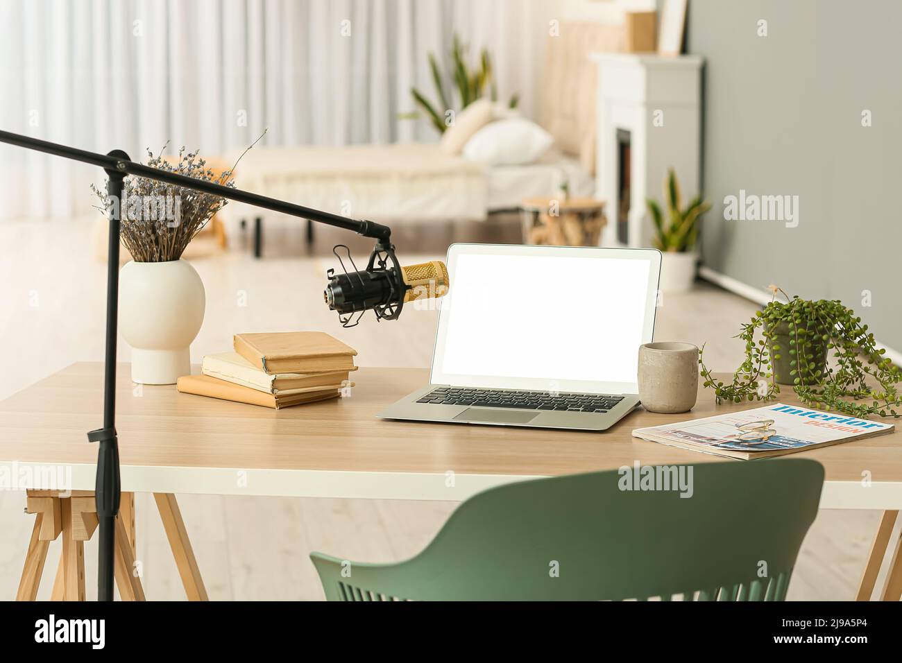 Broadcaster's workplace with modern laptop and professional microphone Stock Photo