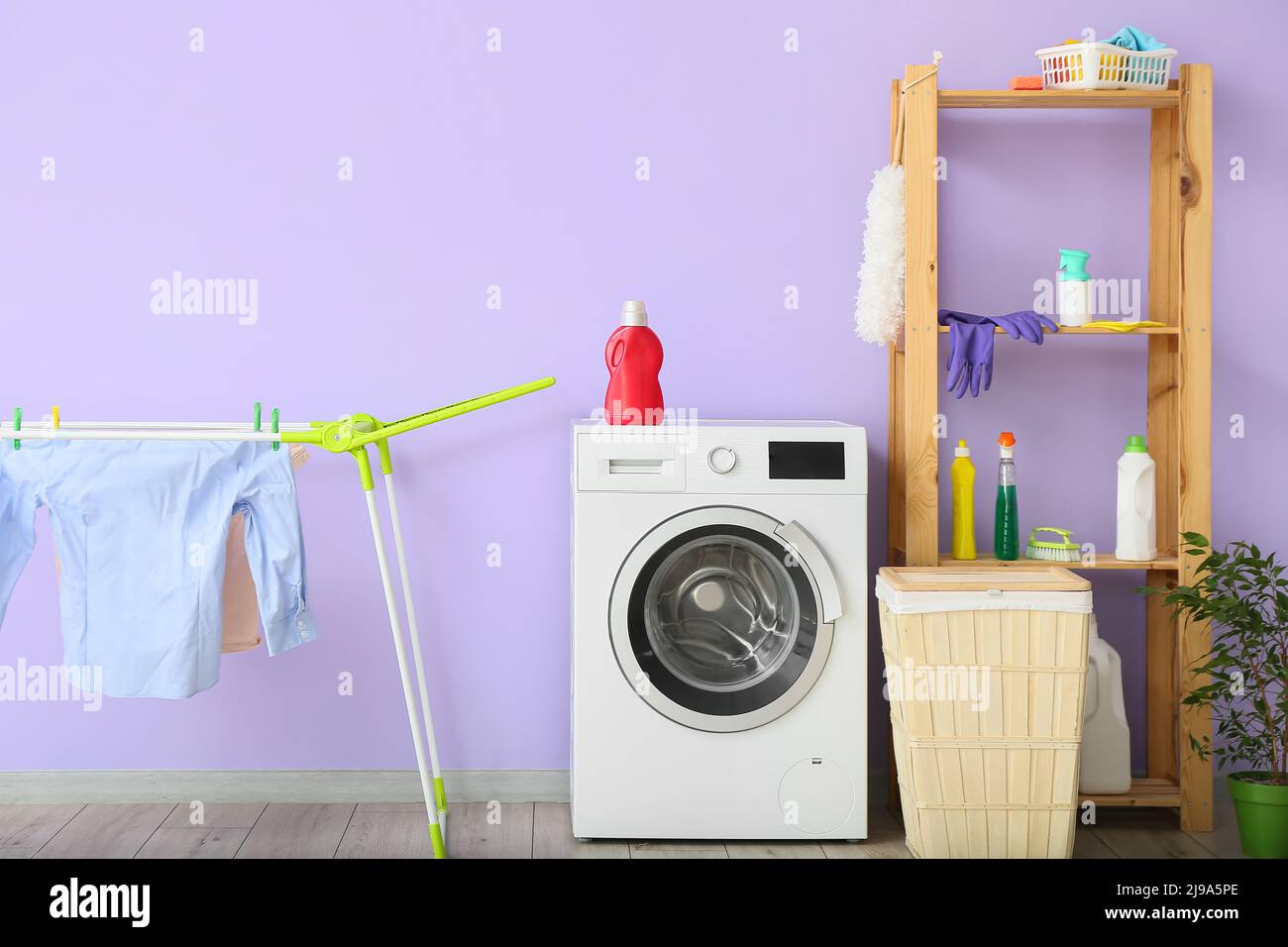 Drying rack, washing machine and shelf unit near color wall Stock Photo ...