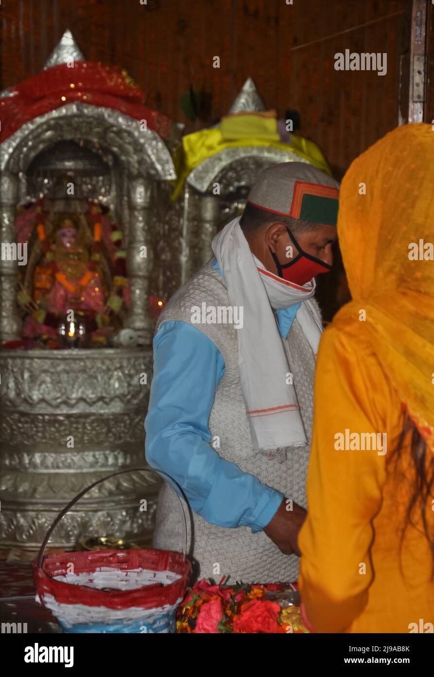 Mandi, Himachal Pradesh, India - 10 17 2021: Photo of a pujari (Priest) with wearing face mask and devotee came to temple for worship Stock Photo