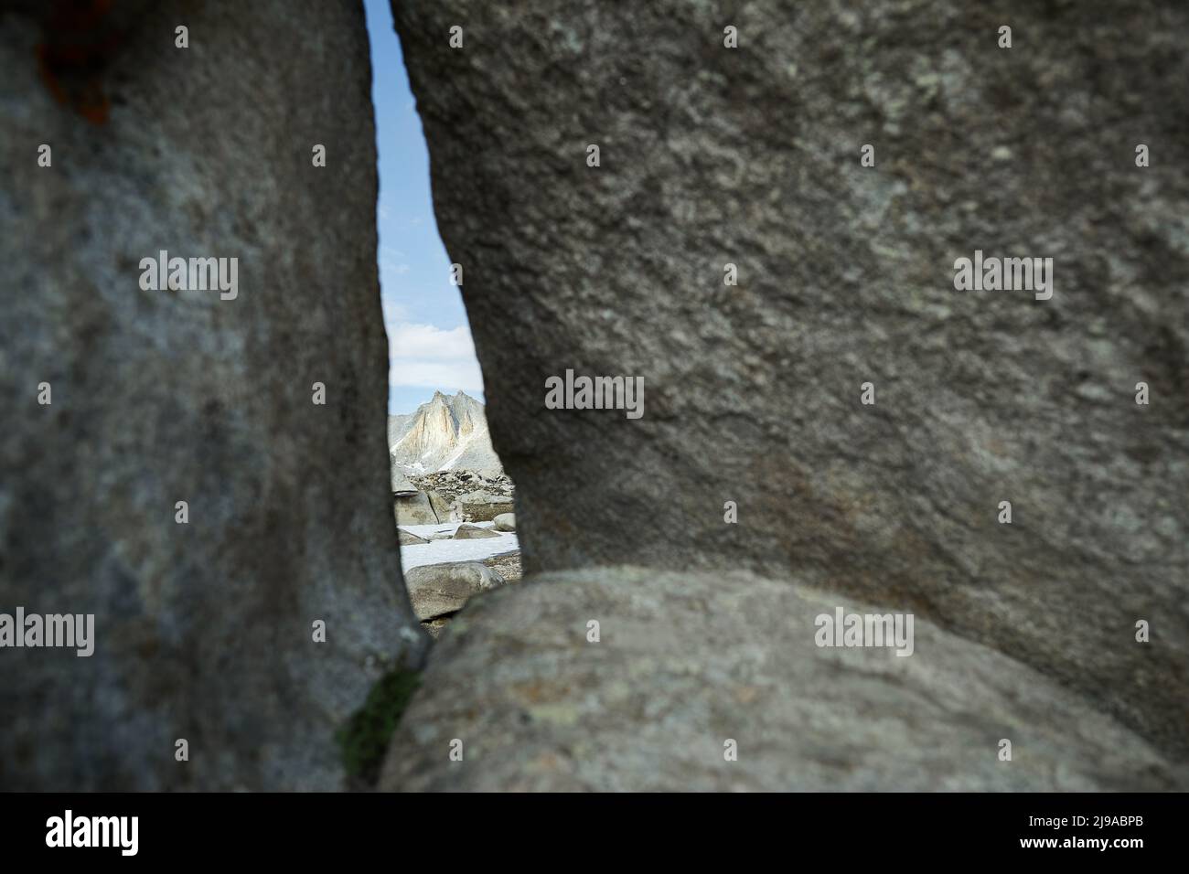 Beautiful scenery of the big rocky mountain trough the crack at cloudy blue in Tien Shan, Kazakhstan Stock Photo