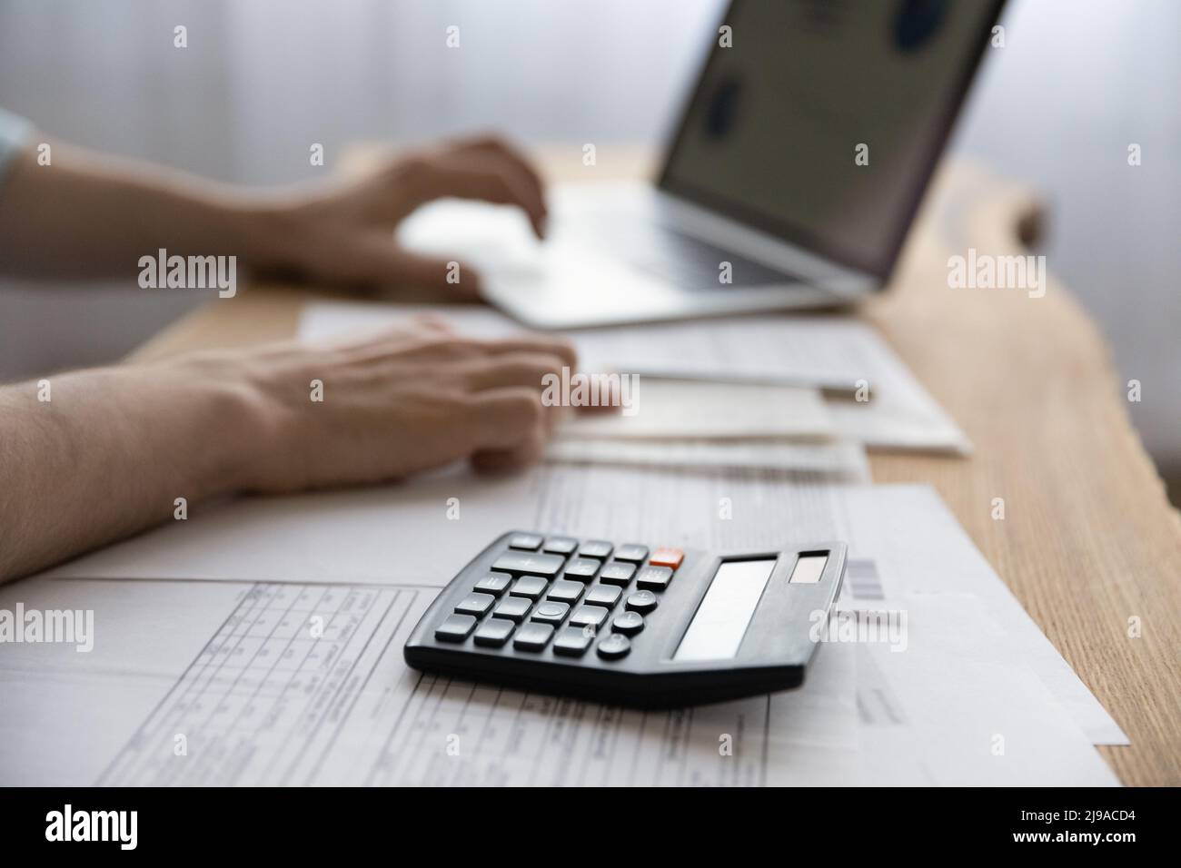 Young man accountant hands working with papers using computer calculator Stock Photo