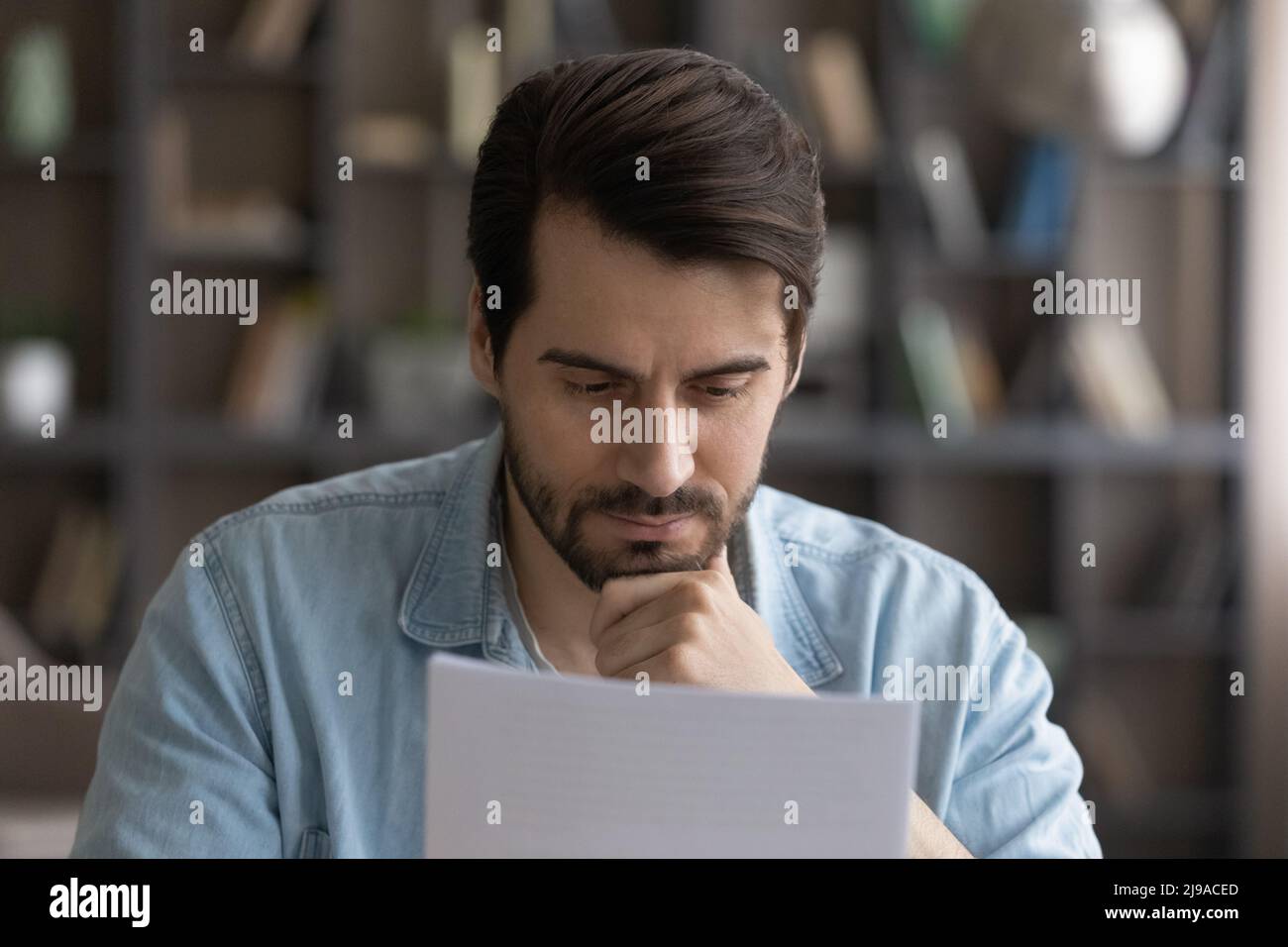 Concentrated serious male small business owner ponder on bank report Stock Photo