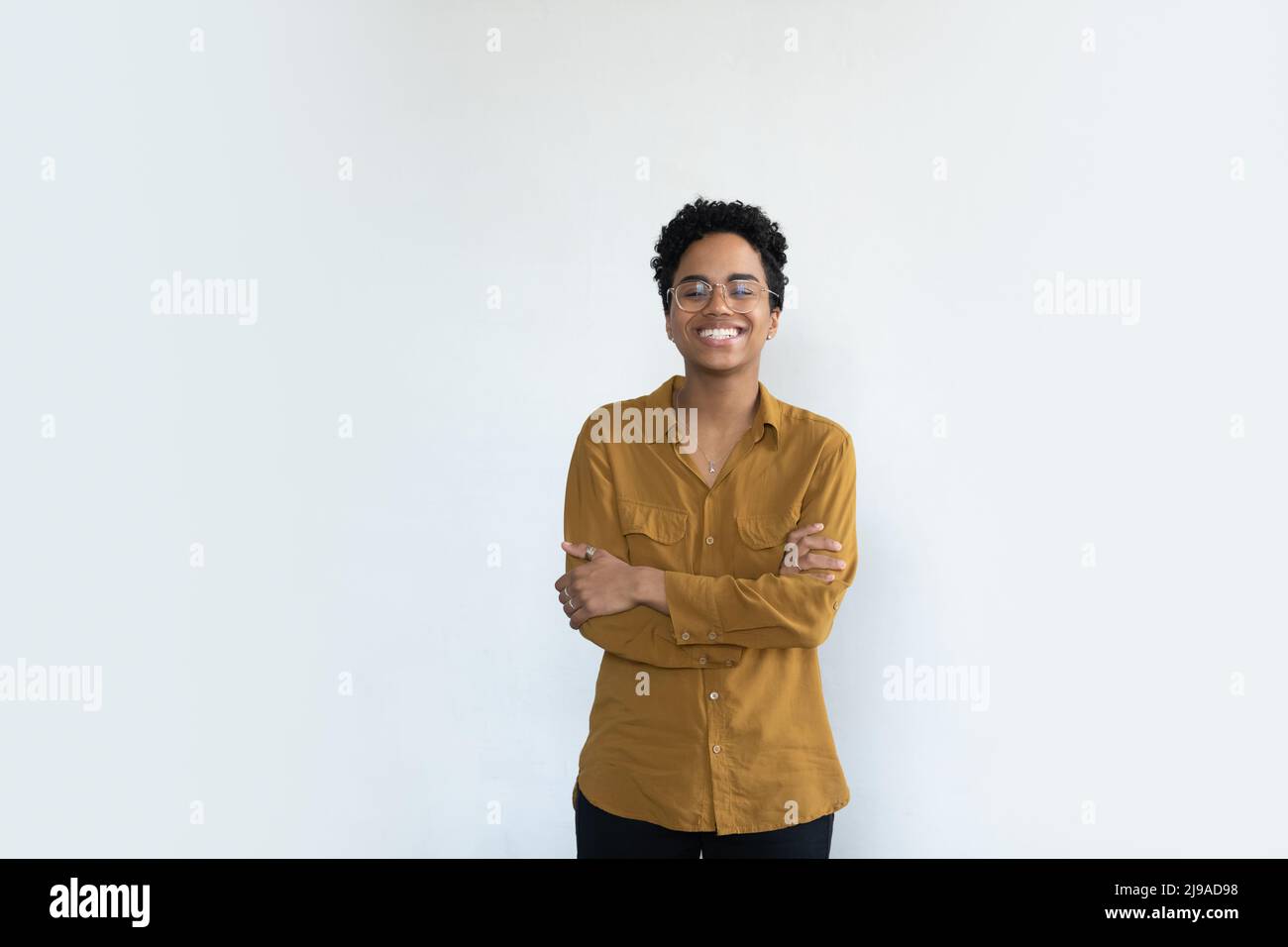 African woman in glasses posing with arms crossed, studio shot Stock ...