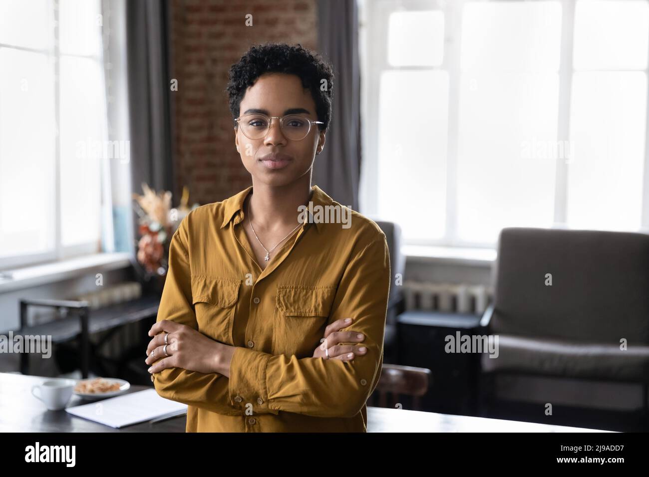Serious confident African businesslady pose cross-armed in company office Stock Photo