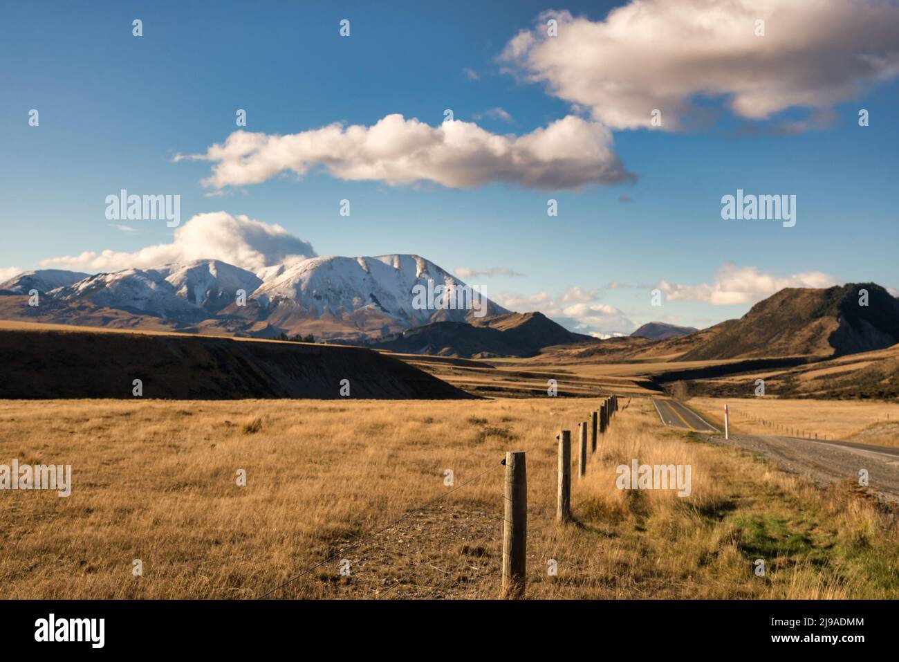 Chasing the snow in the extreme arid Torlesse Tusockland Park in the highlands of NZ Stock Photo