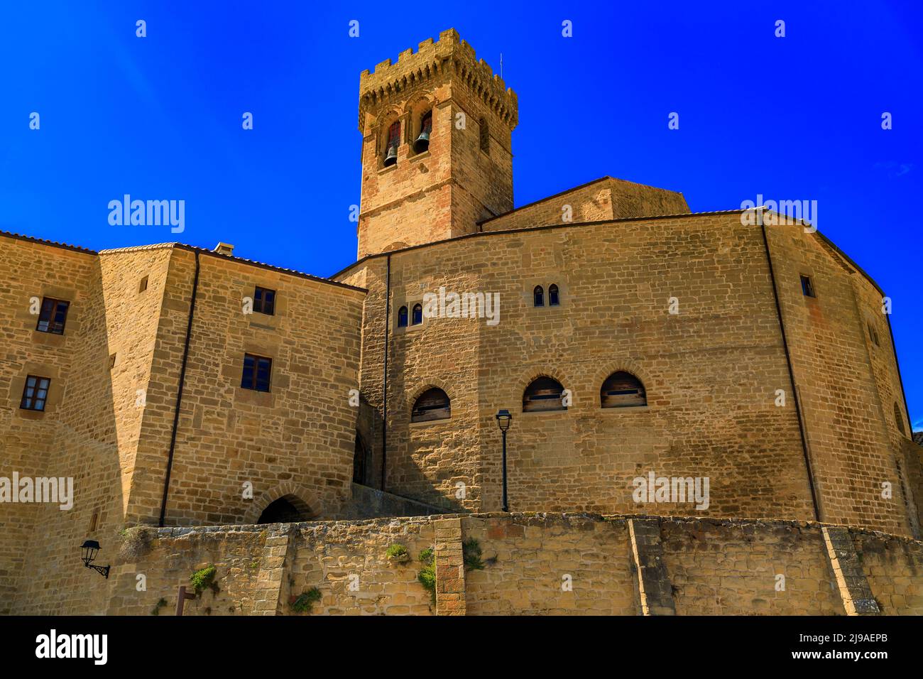 Gothic fortress walls surrounding the Romanesque Iglesia de Santa Maria church built in 11th -14th century in Ujue, the Basque Country, Navarra, Spain Stock Photo