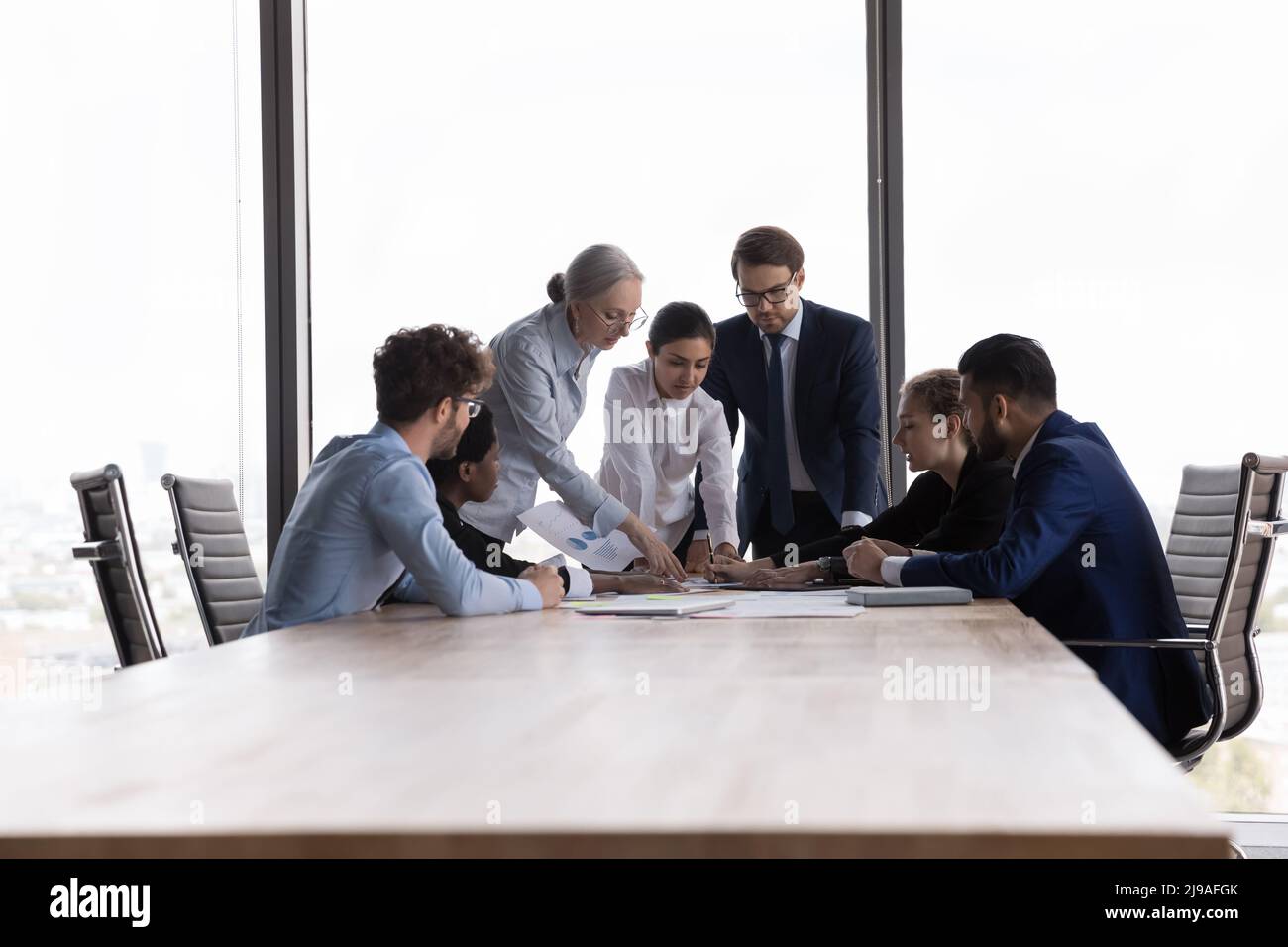 Team of diverse businesspeople discuss financial report at group meeting Stock Photo